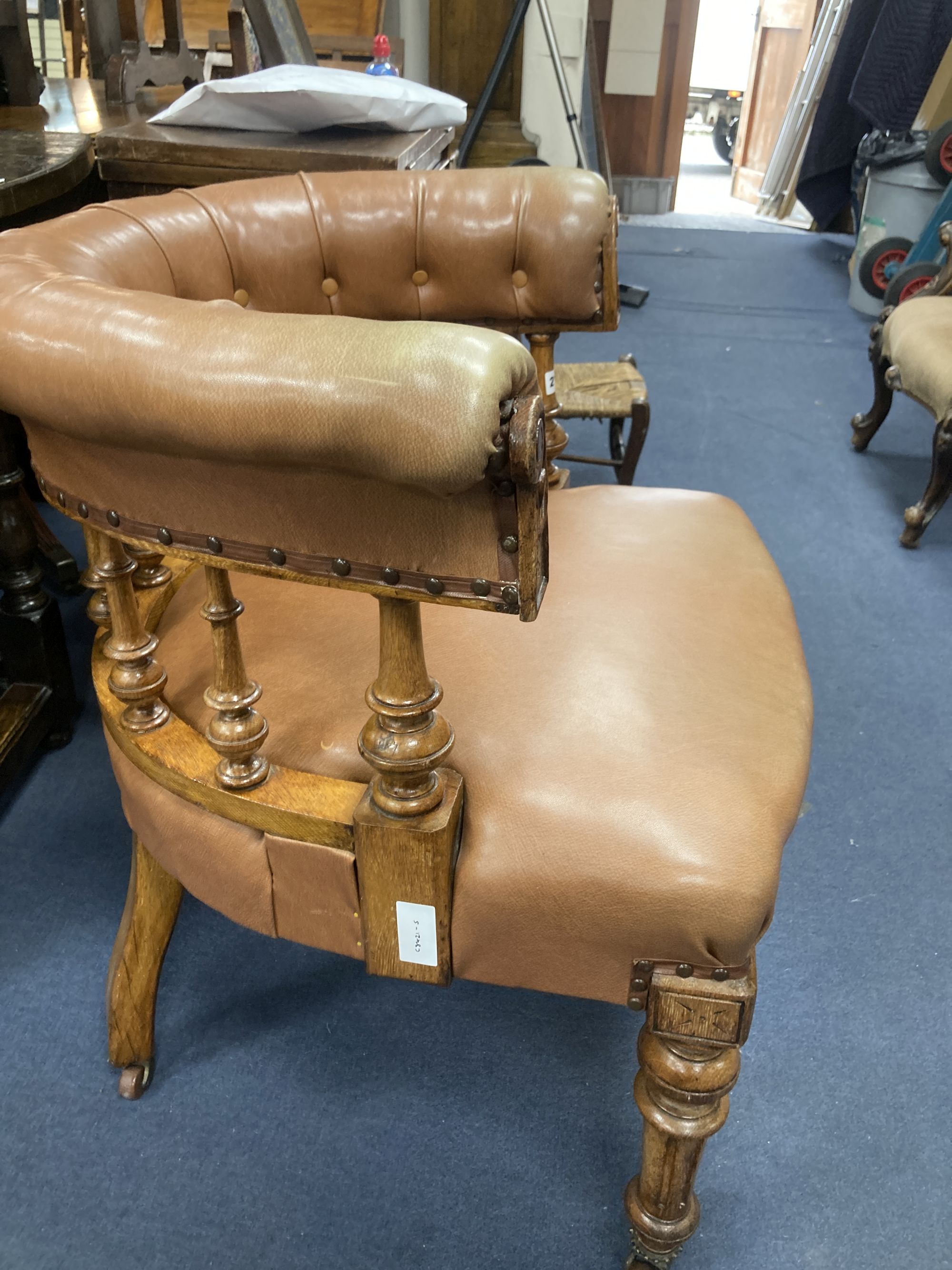 A Victorian oak tub framed library chair, upholstered in brown leather, width 60cm, depth 60cm, height 74cm